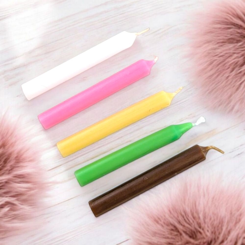 Five colorful fertility blessing candle set with five chime candles on a light wooden surface with pink fur accents.