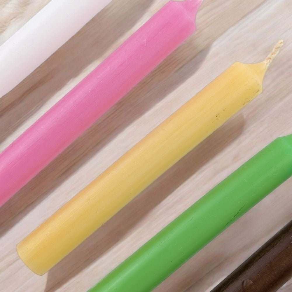 Four colorful fertility blessing candle set with five chime candles (pink, yellow, green) on a wooden surface