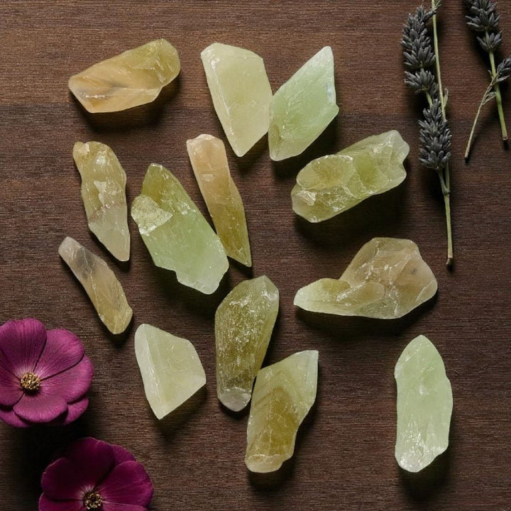 Heart Chakra Crystals - Green Calcite chunks on a wooden surface with flowers and lavender. available at zen collection crystal healing store in barrie