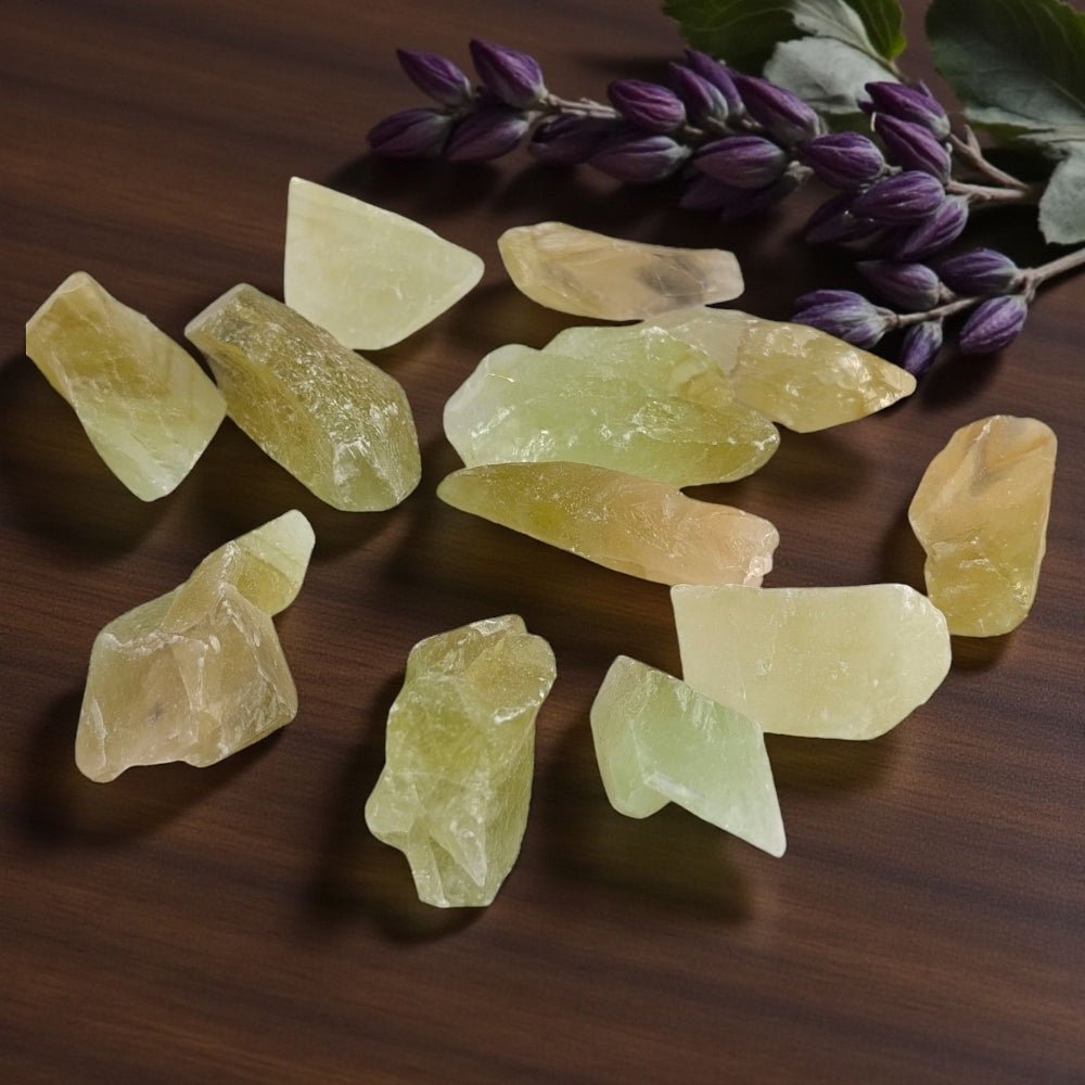 Heart Chakra Crystal - Green calcite crystal chunks on wooden surface with purple flowers in the background available at crystal healing store