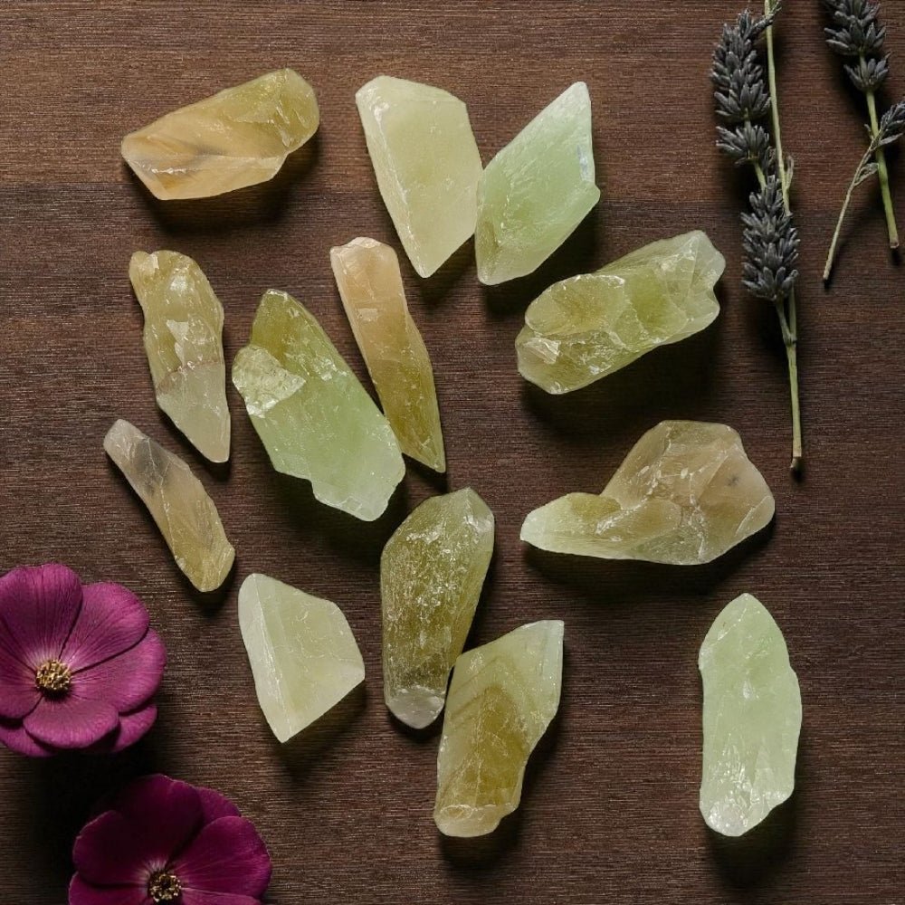 Heart Chakra Crystals - Green Calcite chunks on a wooden surface with flowers and lavender. available at zen collection crystal healing store in barrie
