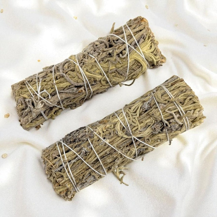 Two bundles of  green sage wrapped in twine on a white fabric background available today at zen collection crystal store