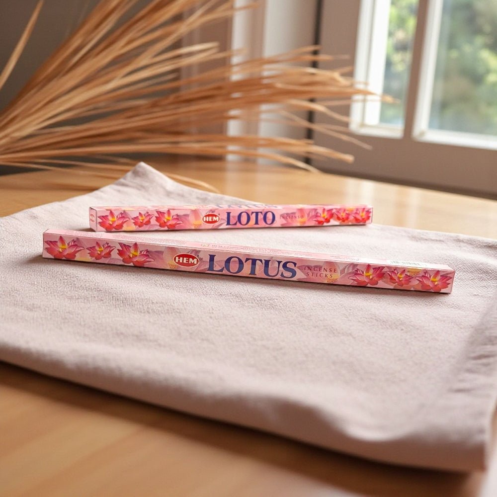 Two packs of HEM Lotus incense on a white cloth with a blurred natural background incense available at Zen Collection metaphysical store near me