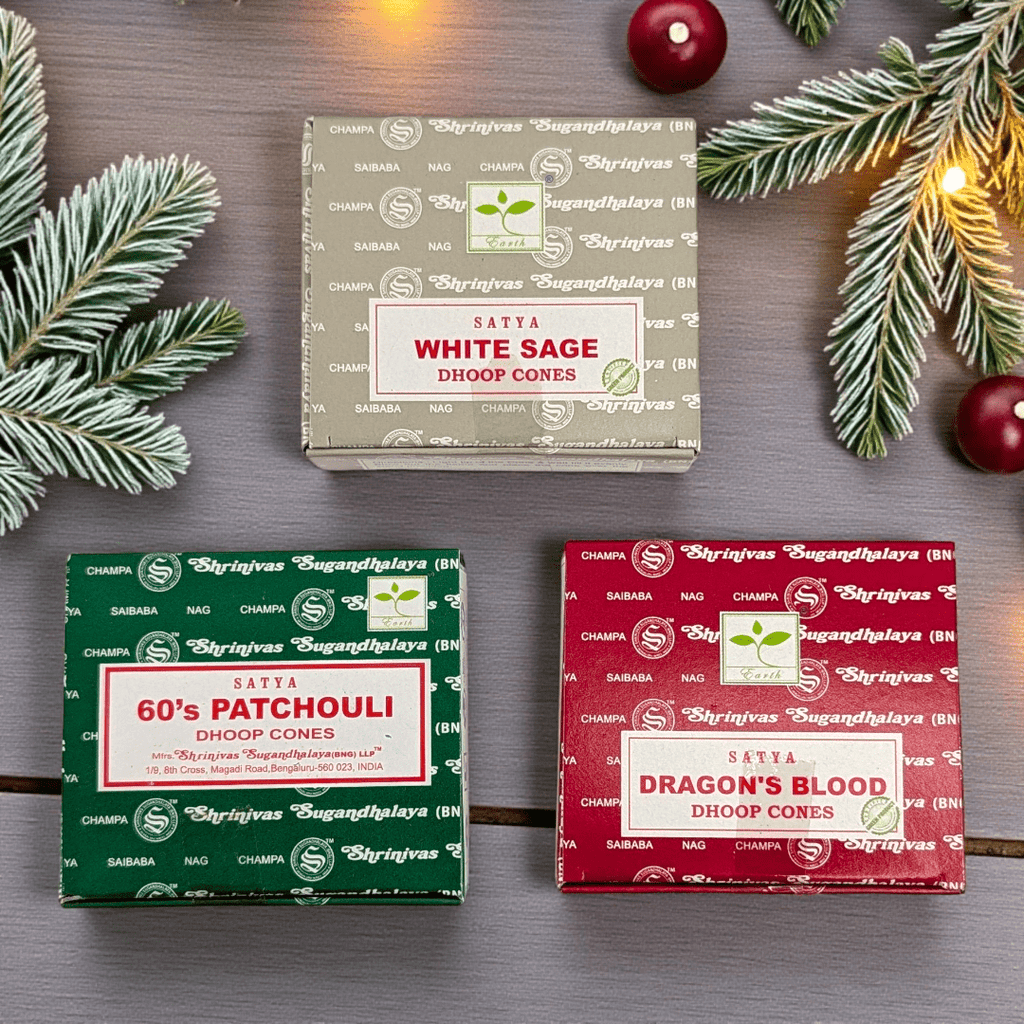 Three boxes of Satya brand doop cones on a wooden surface with Christmas decorations. Available at Zen Collection Metaphysical Stores Barrie