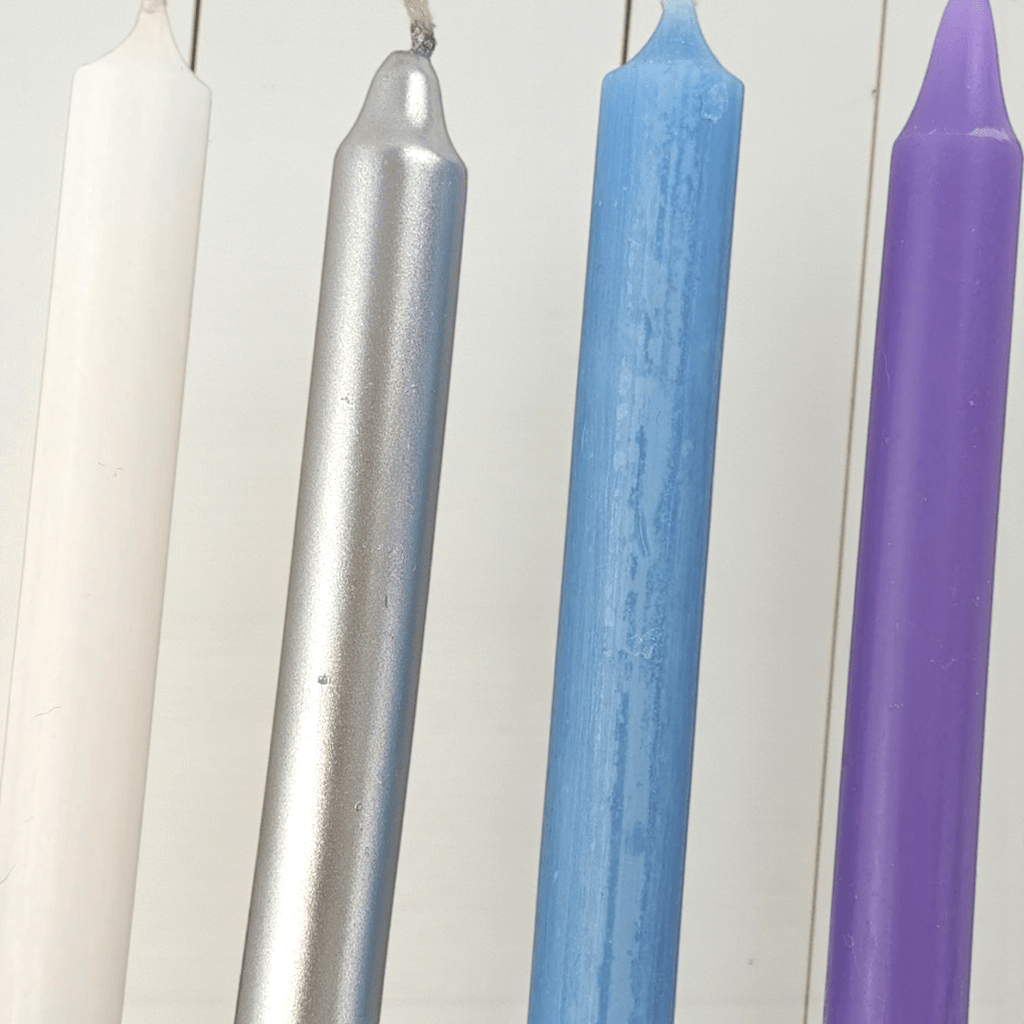 Four colorful spell candles (white, silver, blue, purple) on a white background shop In-Store at our spiritual supply store in Barrie or online 24/7