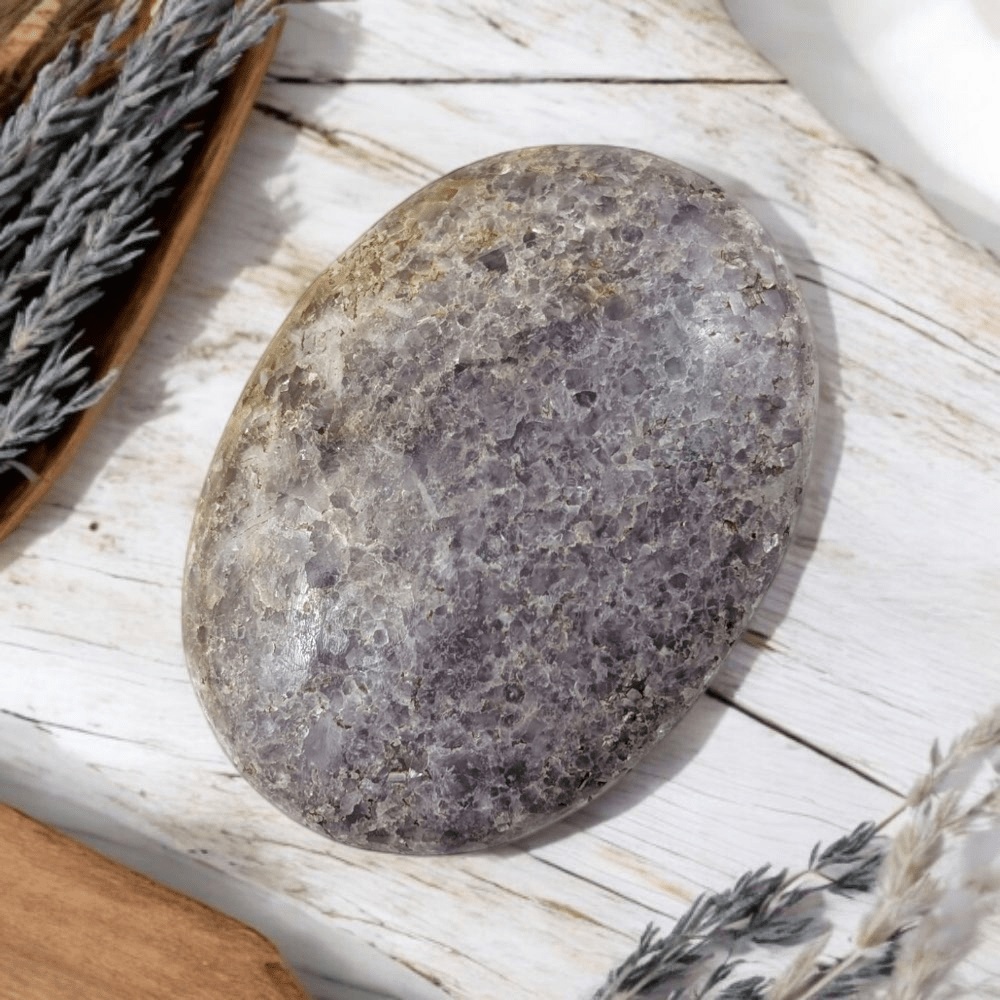 Lepidolite polished palm stone in natural light