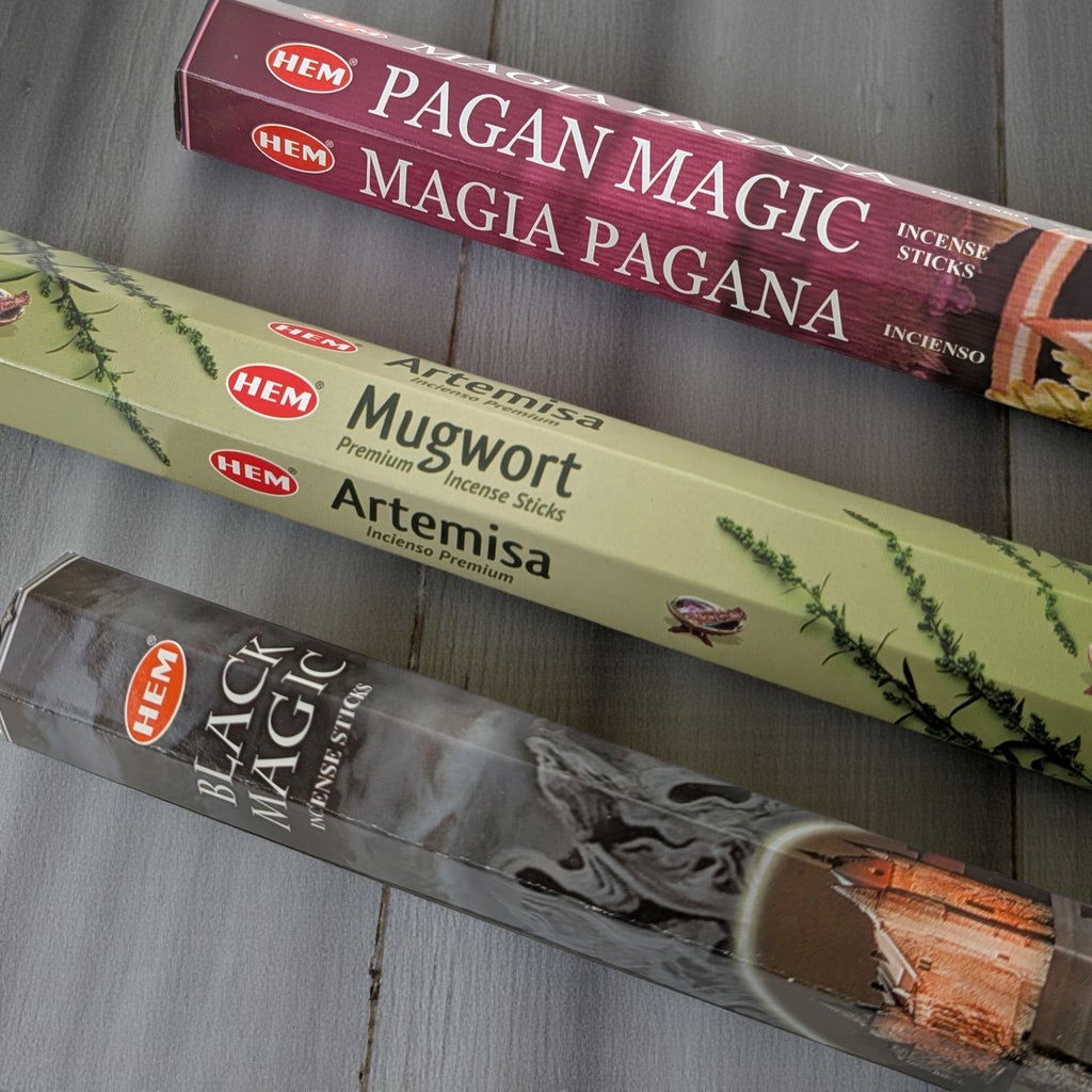 Three boxes of HEM incense sticks labeled 'Pagan Magic', 'Mugwort Artemisa', and 'Black Magic' on a wooden surface. available at zen collection crystal store in barrie