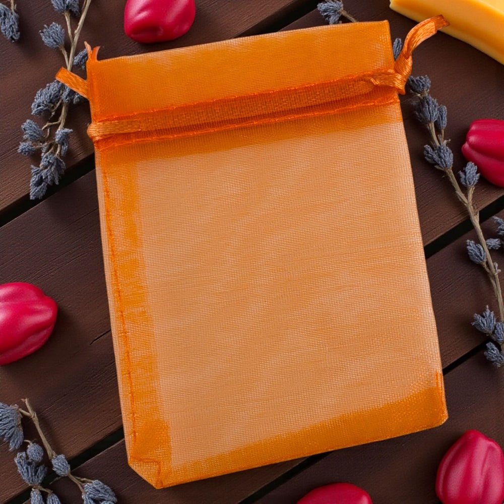 Orange mesh bag on a wooden surface with red peppers and lavender.