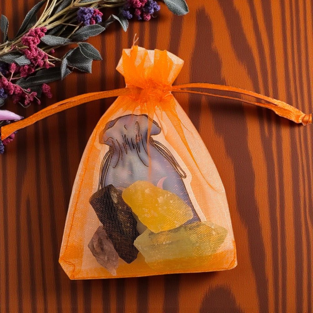 Orange drawstring bag with natural stones on a wooden surface crystal sets available at zen collection metaphysical store  barrie