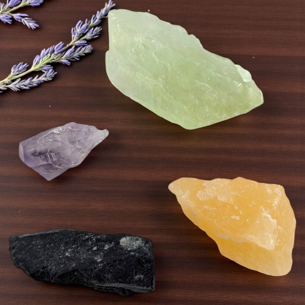 Four different crystals on a wooden surface with a sprig of lavender. purchase now from zen collection crystal store