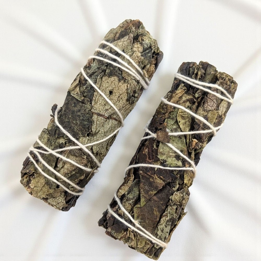 Two bundles of black sage tied with white string on a white background available at zen collection crystal store in barrie