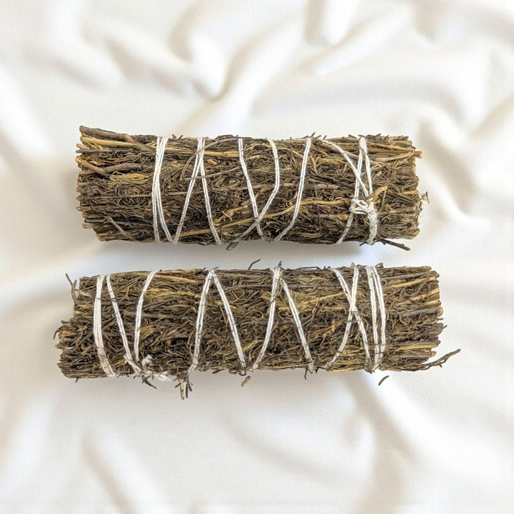 Two copal bundles tied with twine on a light fabric background available at barries top metaphysical store