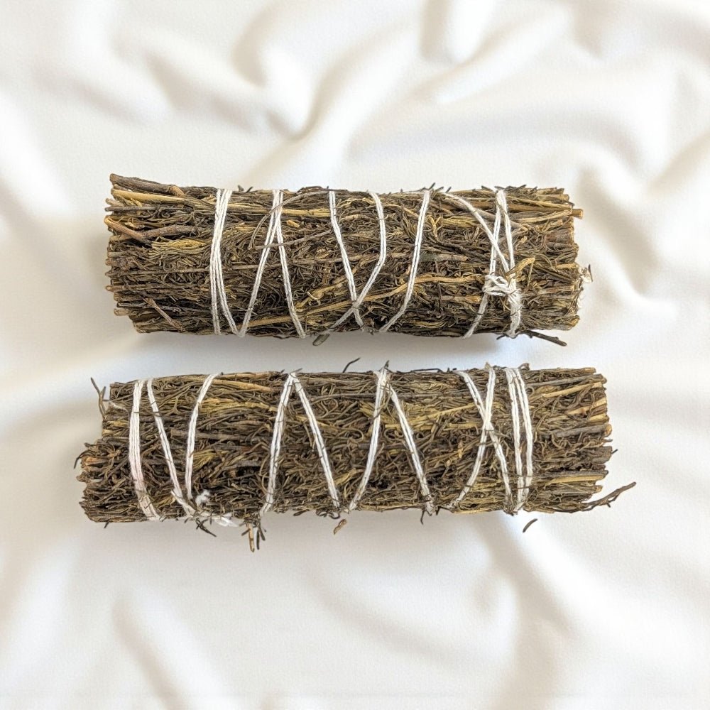 Two copal bundles tied with twine on a light fabric background available at barries top metaphysical store