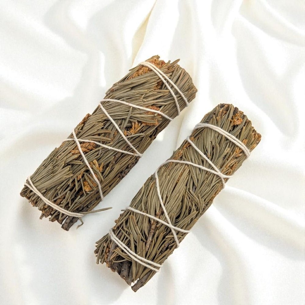 Two bundles of pure pine tied with twine on a white fabric background available at zen collection crystal store