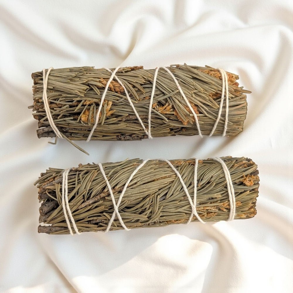 Two pine bundles tied together on a white fabric background purchase now at crystal store in barrie