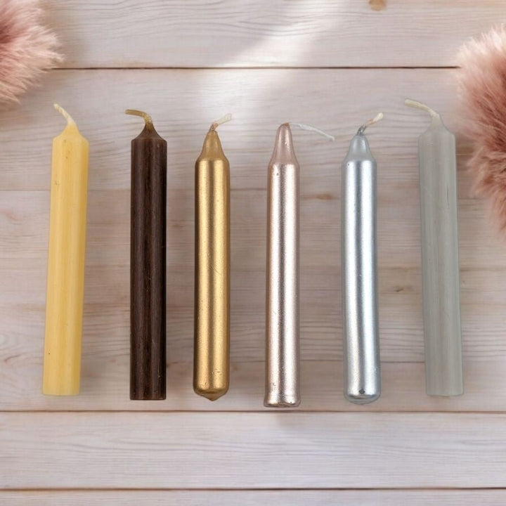 Set of six chime candles on a wooden surface with decorative fluffy elements. from Canada&