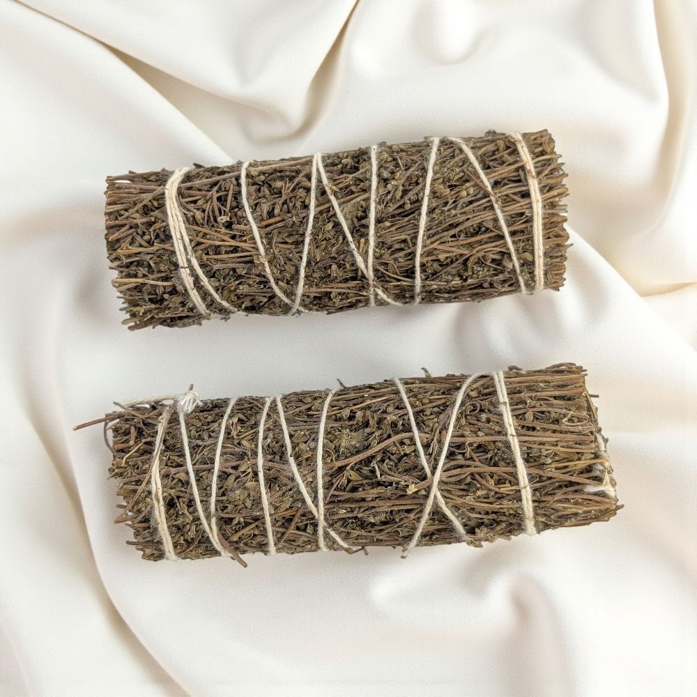 Two bundles of dried Thyme herbs tied with twine on a light fabric background available at crystal store barrie