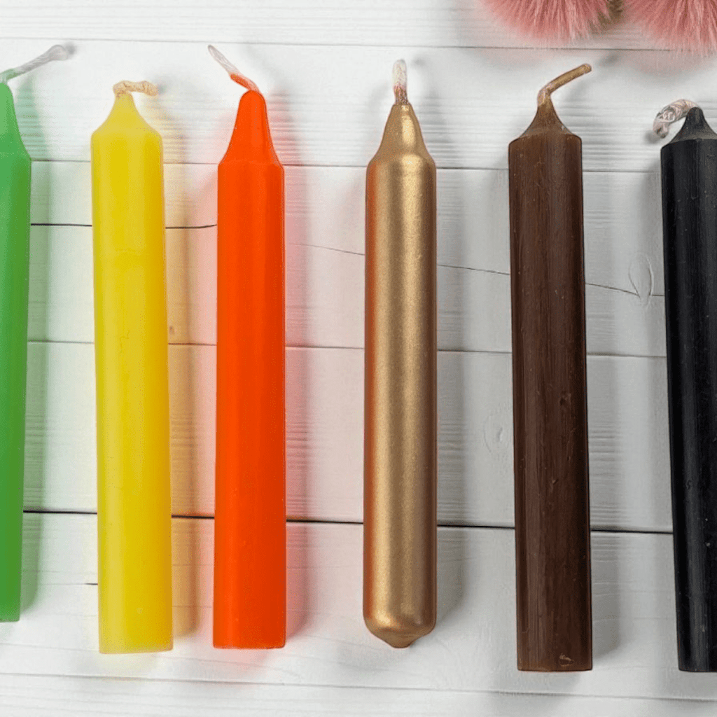Colorful candles arranged in a row on a wooden surface. Abundance candle set available at zen collection crystal shops in barrie