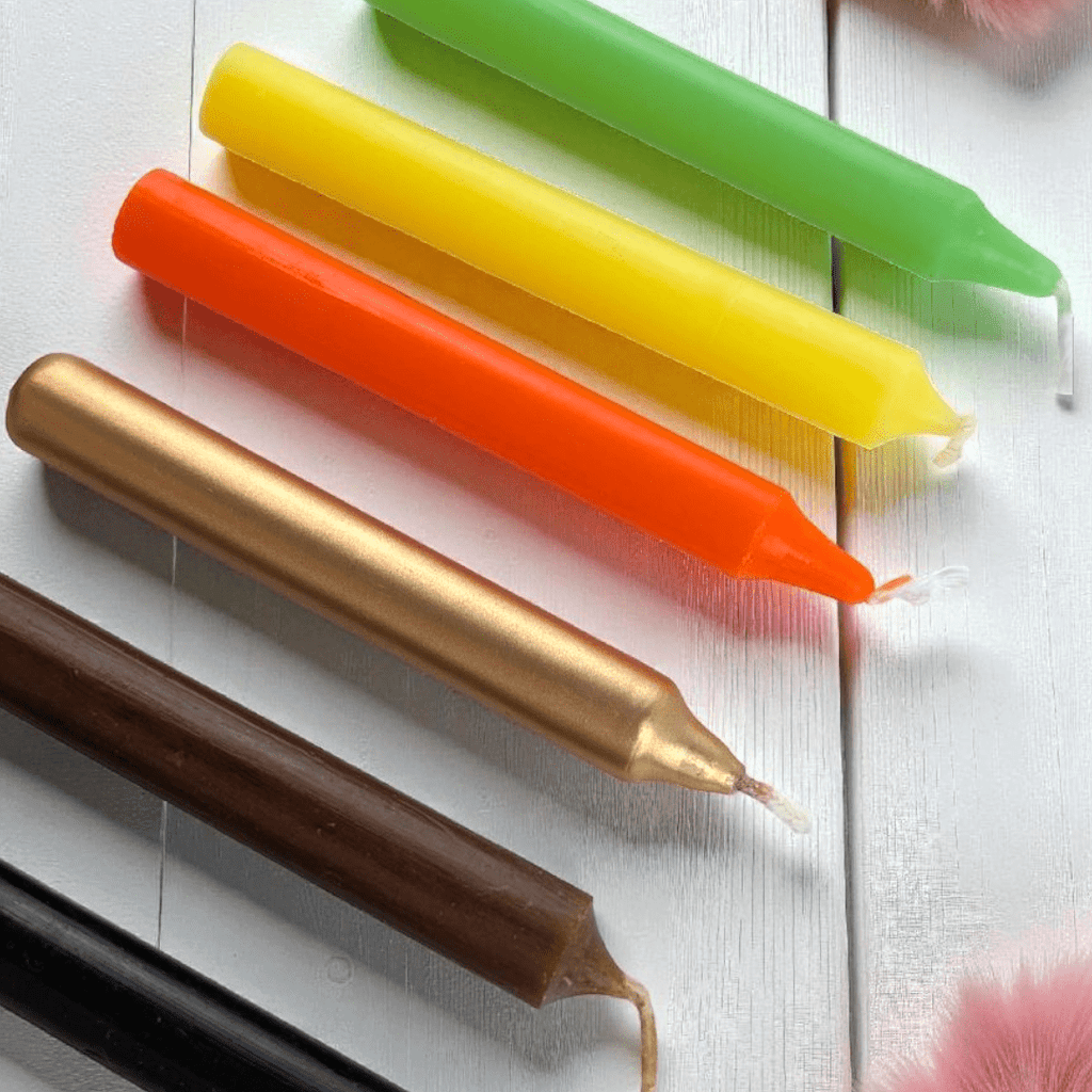 Colorful candles in gold, brown, yellow, and green on a white surface. abundance candle set available at zen collection crystal store in Barrie