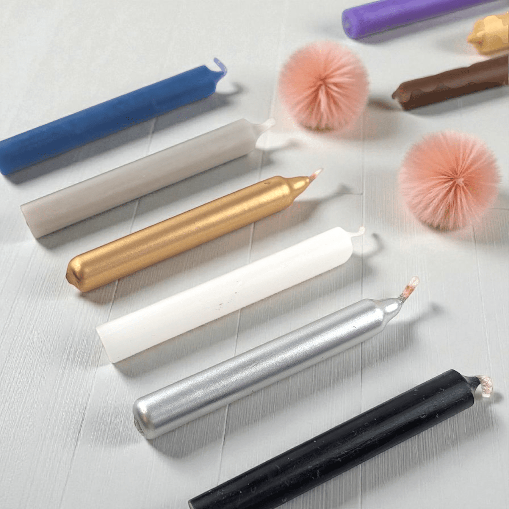 Colorful spell candles on a light surface with decorative elements. Available at zen collection spiritual supply store near me