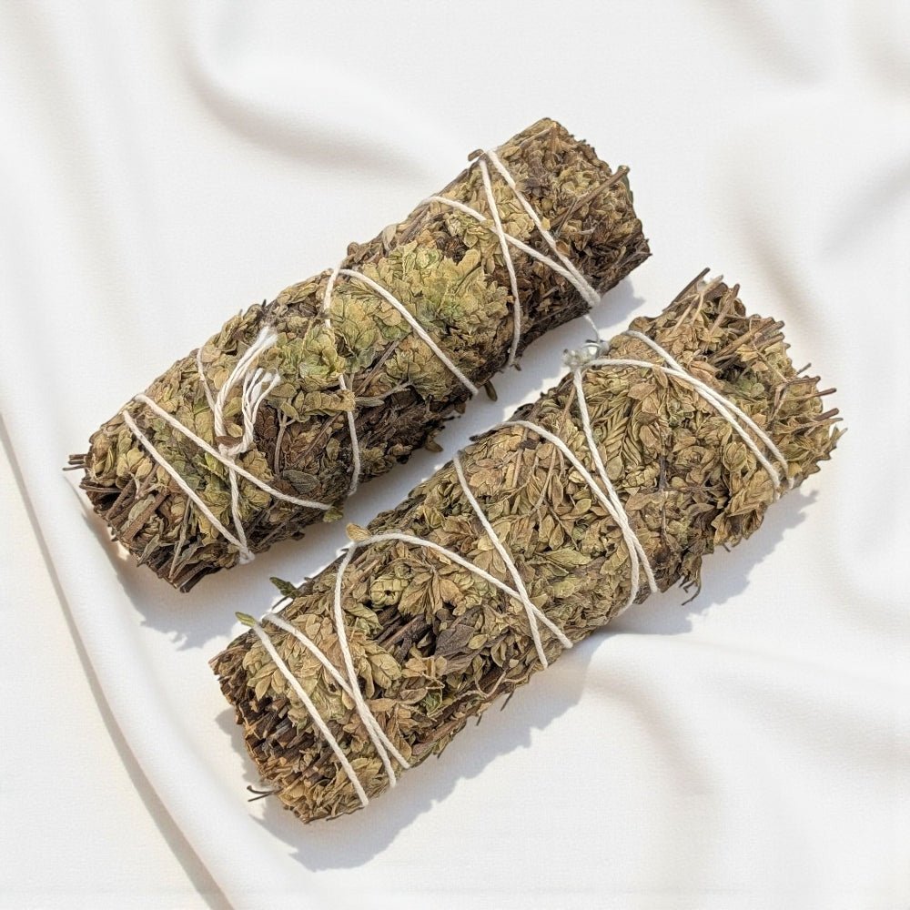 Two bundles of pure oregano bundle for cleansing and protection tied together on a white fabric background available at zen collection new age store