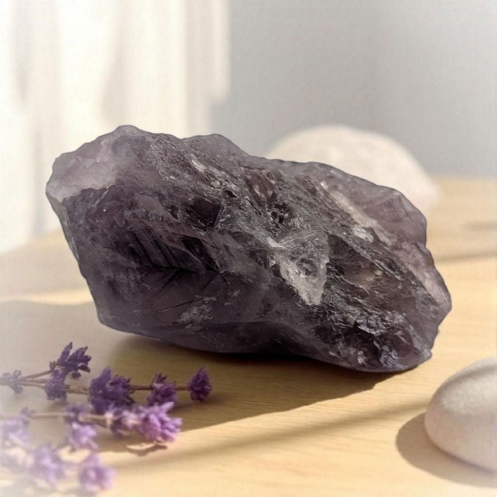 Raw amethyst crystal on a wooden surface with blurred background