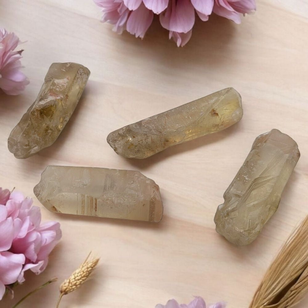 Raw authentic citrine crystals on a wooden surface with pink flower