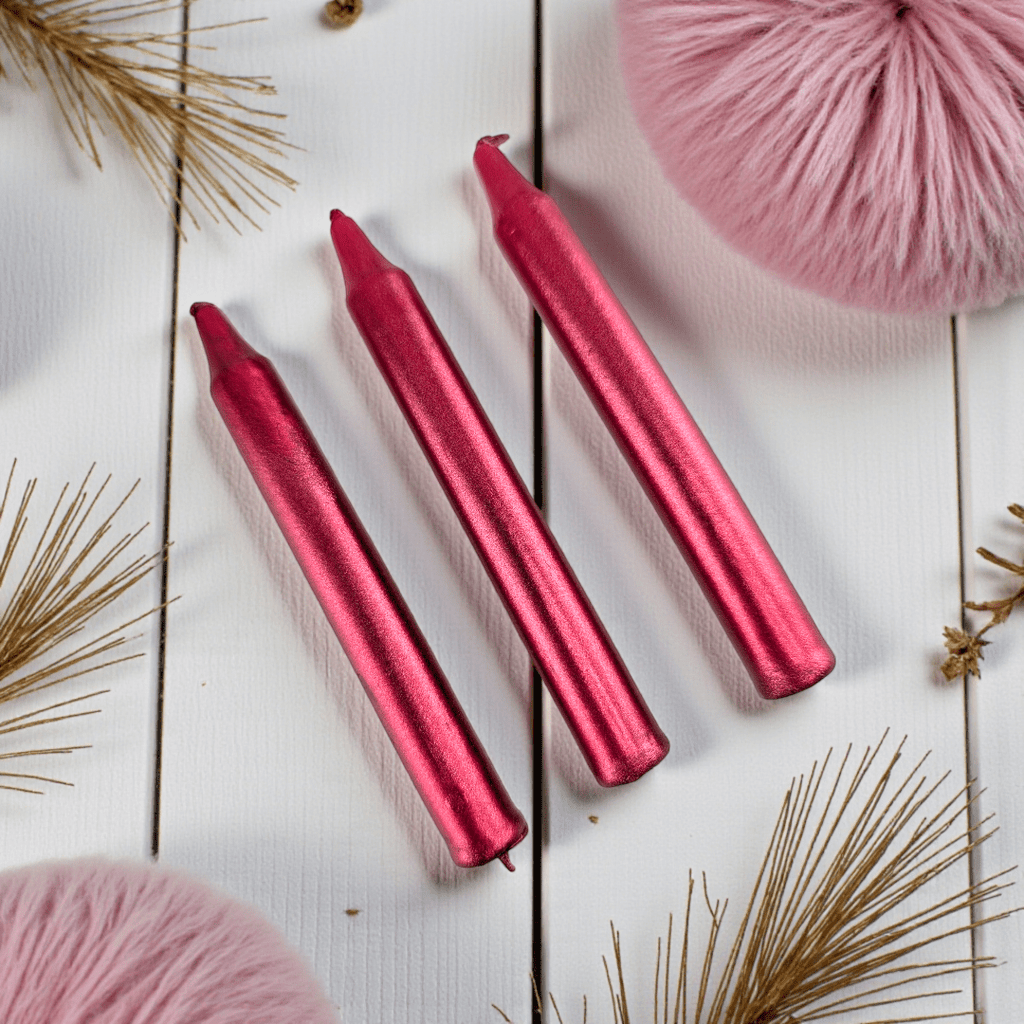 Three red spell candles on a white wooden surface with pink and gold decorative elements. Shop In-Store now or online 24/7 at Zen Collection  Crystal Stores Barrie
