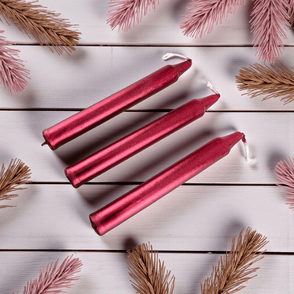 Three red spell candles on a white wooden surface with pink and gold decorative elements. Shop In-Store now or online 24/7 at Zen Collection  Crystal Stores Barrie