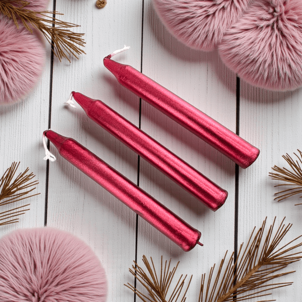 Three red spell candles on a white wooden surface with pink and gold decorative elements. Shop In-Store now or online 24/7 at Zen Collection  Crystal Stores Barrie
