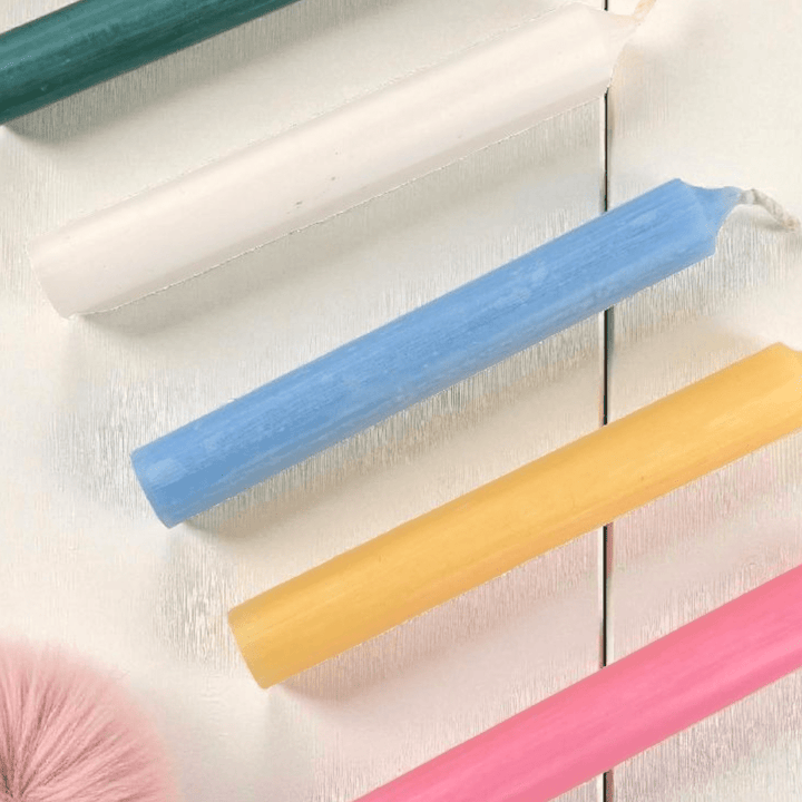 Colorful spell candles on a light wooden surface available at zen collection metaphysical store in barrie