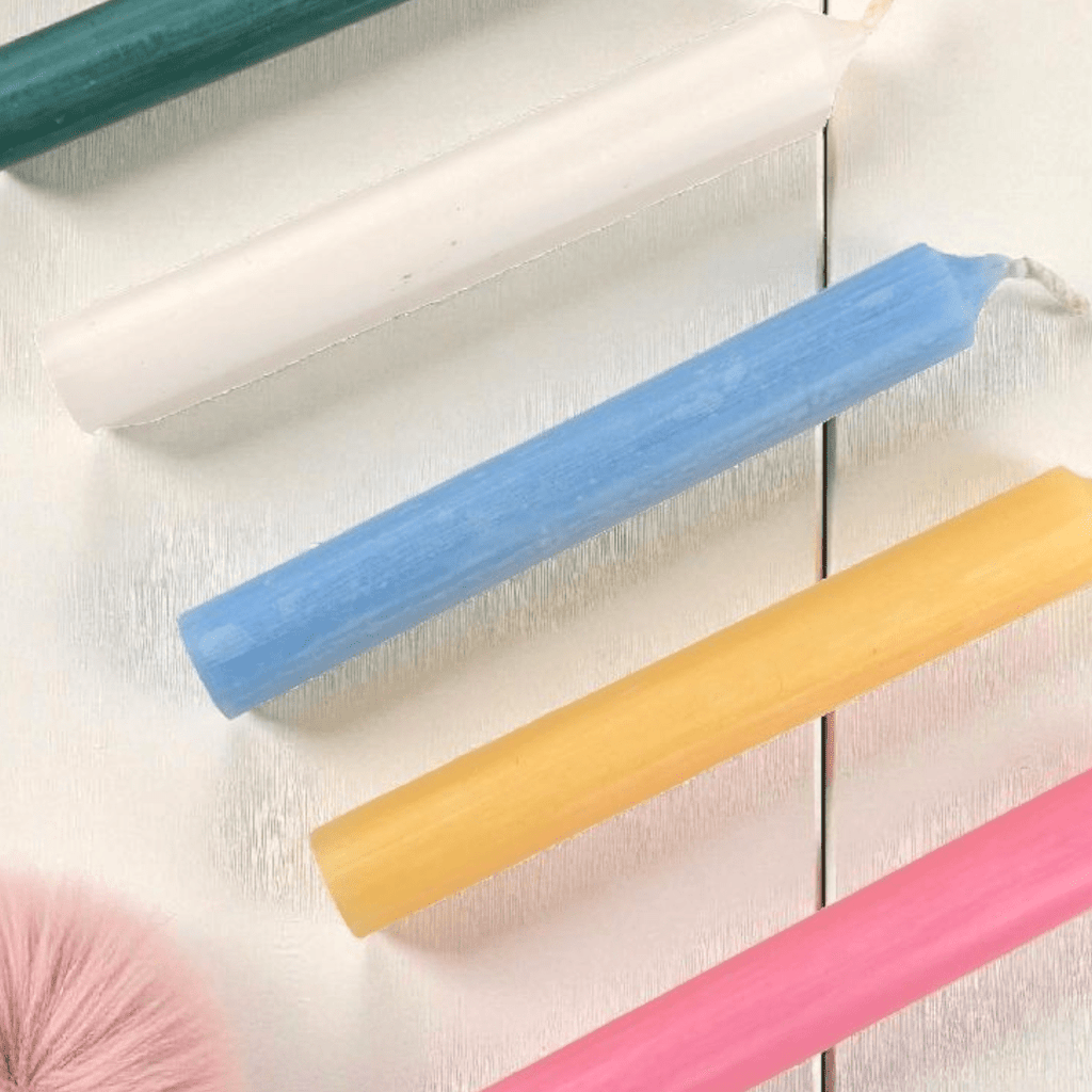 Colorful spell candles on a light wooden surface available at zen collection metaphysical store in barrie