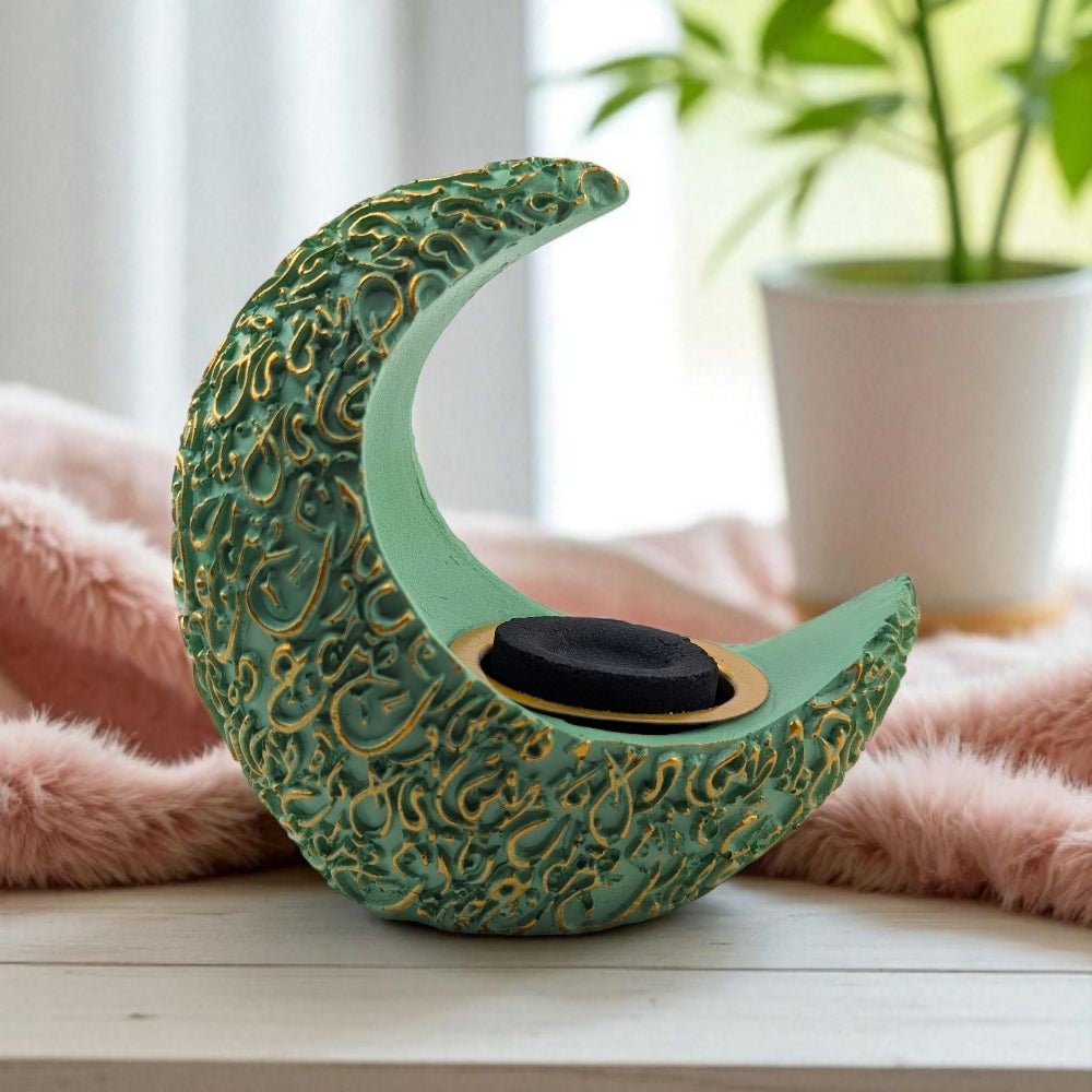 Decorative green crescent moon resin burner on a surface with a blurred background