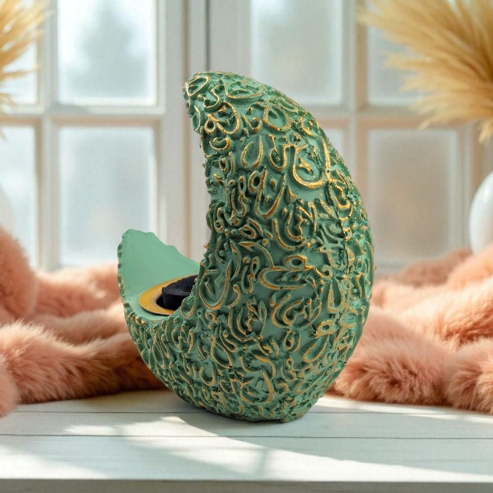 Decorative resin burner resembling a crescent moon with intricate gold patterns on a light surface.