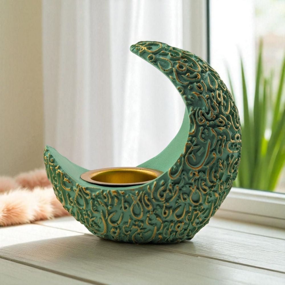 Decorative green and gold crescent moon-shaped resin burner on a windowsill.