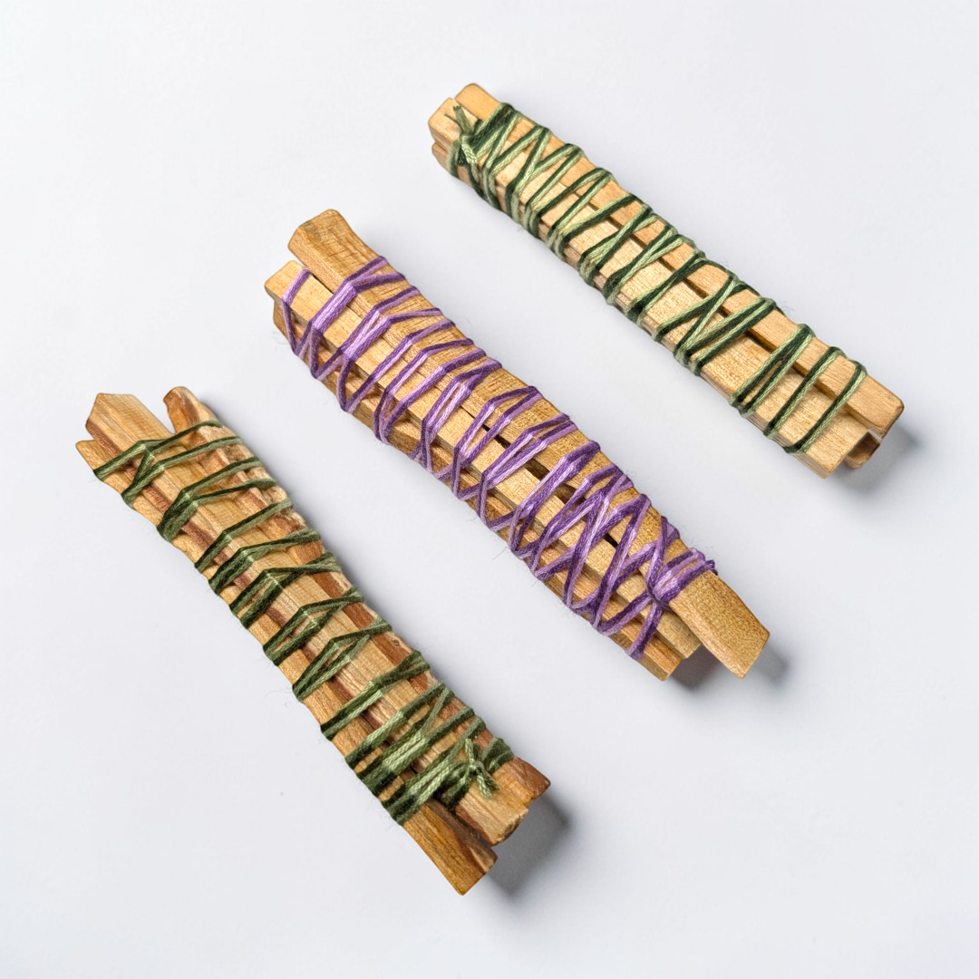 Palo Santo sticks on a stone tray surrounded by crystals