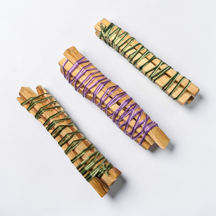 Palo Santo sticks on a stone tray surrounded by crystals