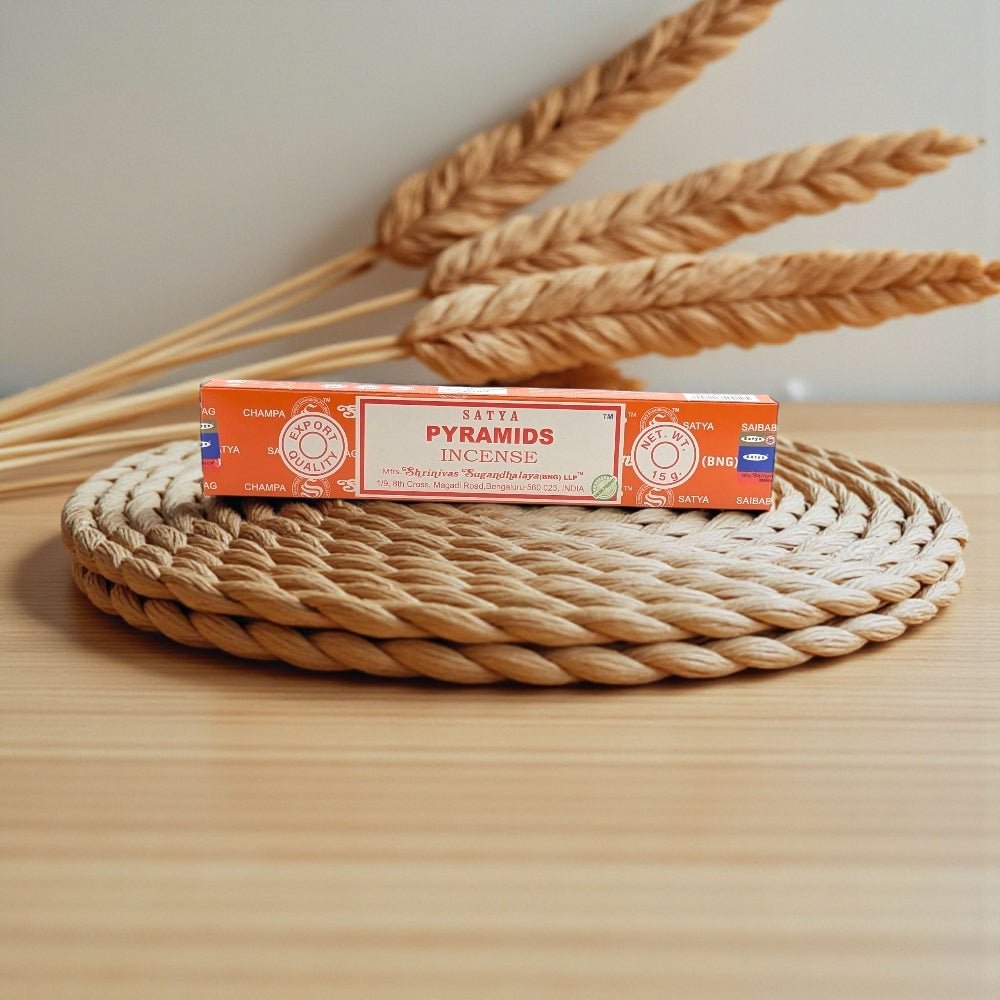 Satya Pyramids incense box on a woven mat with wheat stalks in the background. incense near me is available at zen collection spiritual store
