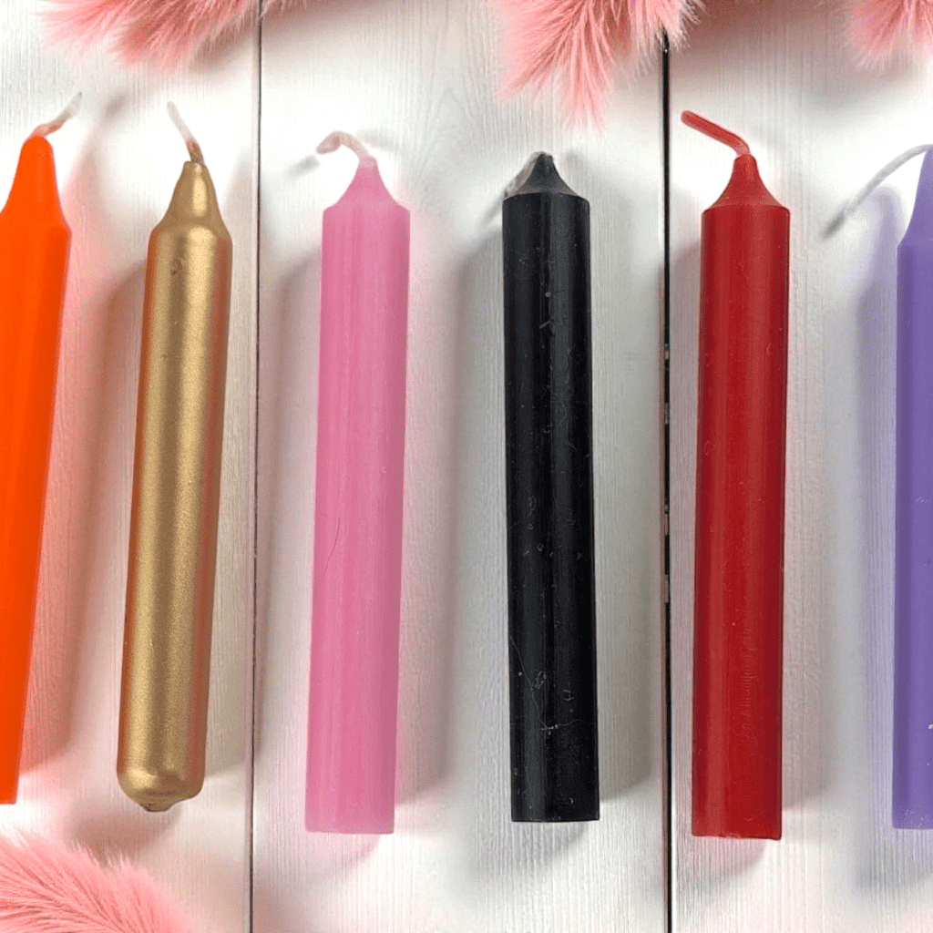 Colorful candles arranged in a row on a textured surface with decorative elements. available at zen collection metaphysical store in barrie