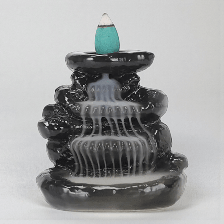 Black ceramic incense burner with a blue incense stick on a white background. Available at Zen Collection Metaphysical store in Barrie. Shop in-store or online now