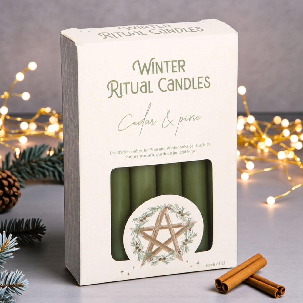 Packaging of Winter Ritual Candles with candles inside, surrounded by decorative lights and pine branches. Available at Zen Collection Crystal Stores near me