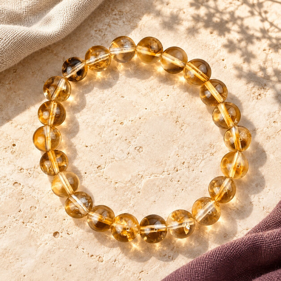 Citrine bracelet with translucent honey-gold beads styled on warm limestone.