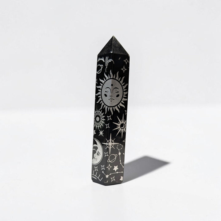 Zen Collection black obsidian crystal tower featuring intricate silver celestial engravings of sun, moon, and stars.