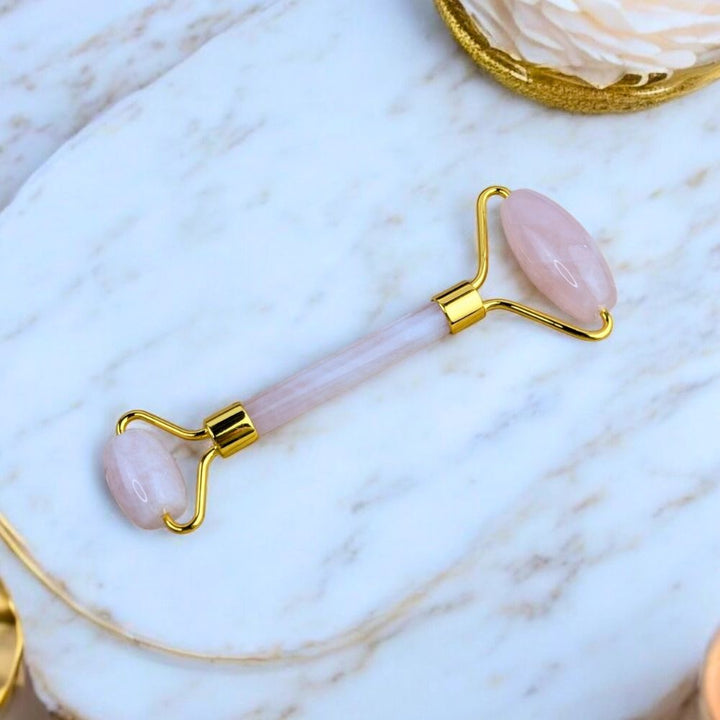 Rose Quartz Facial Roller  on a marble surface.- Zen Collection